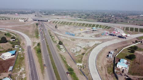 Slow-rising-aerial-drone-view-of-the-Interchange-of-Samruddhi-Mahamarg-also-known-as-Nagpur-to-Mumbai-Super-Communication-Expressway,-an-under-construction-6-lane-highway
