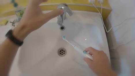 pov-brushing-teeth-in-the-morning-in-white-sink-with-electric-toothbrush
