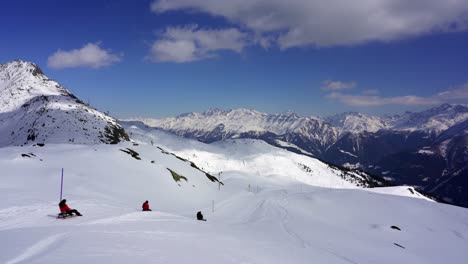 Aletsch-Arena-Winterskigebiet,-Glückliche-Touristen-Rutschen-Eine-Piste-Auf-Einem-Schlitten-In-Den-Schneebedeckten-Bergen-Der-Alpen,-Schweiz