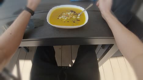 Pov-En-Primera-Persona-Comiendo-Sopa-De-Calabaza-Naranja-Afuera