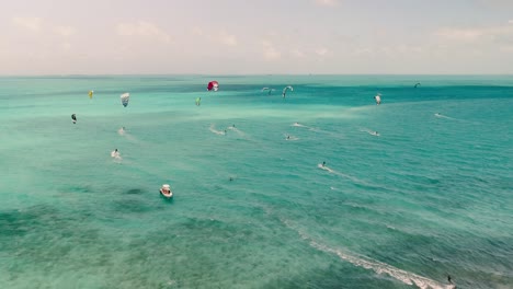 kite-safari-caribbean-sea,-aerial-view-multiple-kite-sailing-with-white-safety-boat