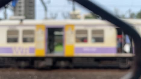 Blurred-View-Of-Local-Train-Moving-On-Railway-In-Slow-Motion-In-Mumbai,-India