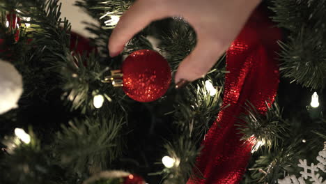 Nahaufnahme-Einer-Hand,-Die-Ornamente-Auf-Den-Weihnachtsbaum-Legt---Vertikales-Video