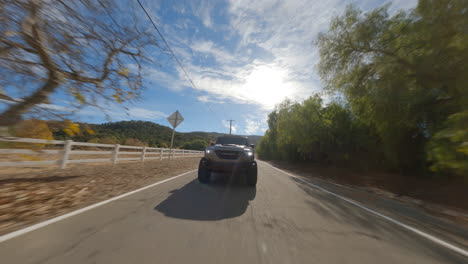 Fpv-drone-of-black-pick-up-driving-fast-on-road
