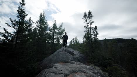 Caucasian-Woman-Hiker-Running-Down-A-Big-Rock-Nature-Trail-At-Saint-Come,-Quebec,-Canada