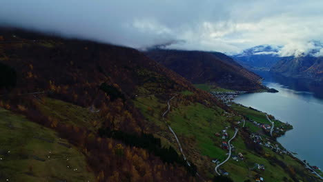 Aerial-dolly-out-revealing-an-autumn-landscape-of-the-fjords-and-a-small-village-on-the-mountainside-in-Norway