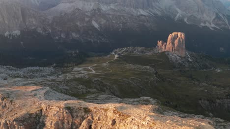 Cinque-Torri-highlighted-by-sun-below-imposing-Tofana-di-Rozes,-Dolomites