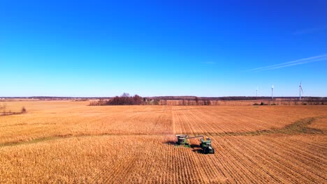 Heavy-machinery-harvesting-corn-on-farm-in-sunny-day