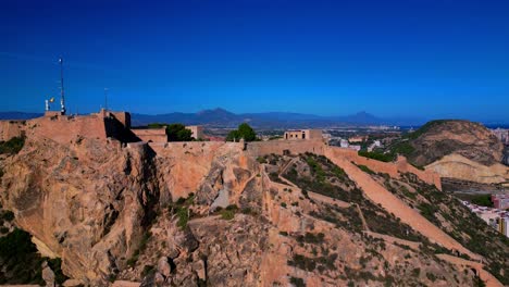 Aerial-footage-of-castillo-de-santa-barbara-in-Alicante-Spain,-with-the-city-in-the-background