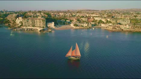 Drone-view-of-sailing-boat-near-resorts-in-Newport-Beach