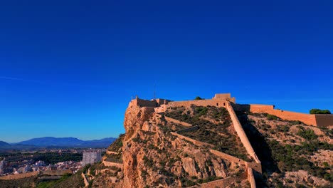 4K-Luftaufnahmen-Von-Castillo-De-Santa-Barbara-In-Alicante,-Spanien,-Mit-Der-Stadt-Im-Hintergrund