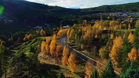 Vista-De-Pájaro-Sobre-Las-Montañas-En-Noruega-Con-Un-Camino-Que-Serpentea-A-Través-De-Los-Bosques-Verdes