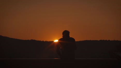 Silhouette-Man-Using-Telescope-at-Sunset-Or-Sunrise