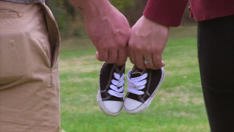 A-man-and-a-woman-hold-little-boy's-shoes