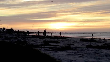 Men-fishing-on-a-beach-at-sunset