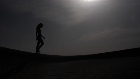 Silhouette-of-a-man-walking-across-the-desert-in-slow-motion