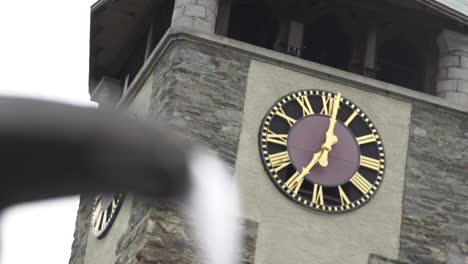 Shift-focus-on-spring-water-to-clock-tower-in-Zermatt-town