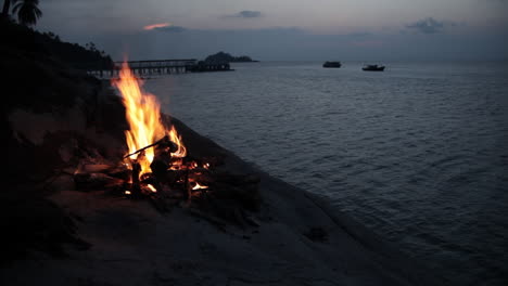 Camp-fire-on-a-hill-of-island-with-overview-of-sea-during-magic-hour