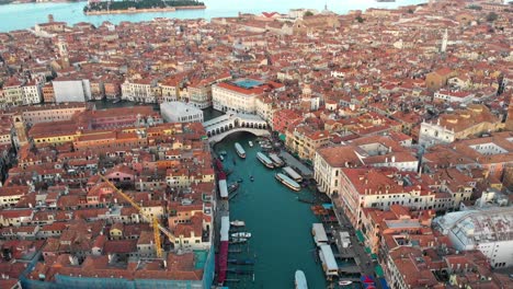 En-Venecia-Italia,-El-Dron-Gira-A-La-Izquierda-Mientras-Sigue-El-Gran-Canal-Destacando-El-Puente-De-Rialto