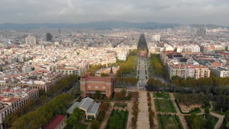 En-Barcelona-España,-El-Dron-Vuela-A-La-Izquierda-Y-Gira-A-La-Derecha-Mientras-Muestra-La-Ciudad-De-Barcelona-Y-El-Monumento,-Arco-De-Triunfo