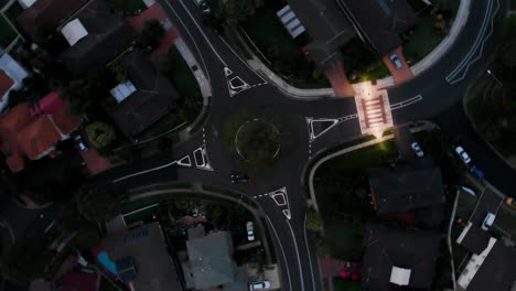 Rotating-aerial-shot-of-a-roundabout-at-night-with-cars-driving-past