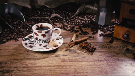Die-Kamera-Schiebt-Sich-Zurück-Und-Zeigt-Eine-Frisch-Gezapfte-Espressotasse-Mit-Zimt,-Sternanis-Und-Frisch-Gerösteten-Kaffeebohnen-Auf-Einem-Holztisch