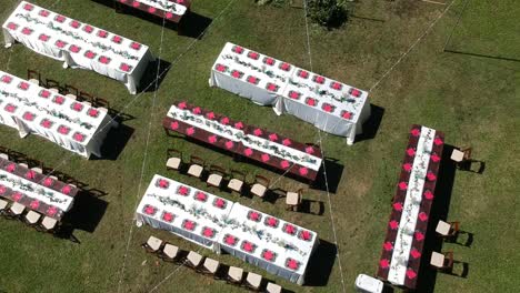 Drone-shot-showing-hawaii-mountains-and-outdoor-wedding-catering-tables-laid-ready-for-the-dinner-with-lighting-above-the-tables