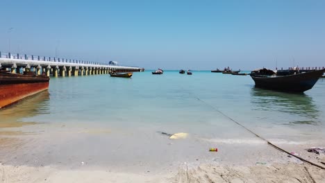Various-local-and-fishing-boats-moored-up-for-low-tide-and-the-island-jetty-in-the-background-and-the-andaman-sea-and-blue-sky