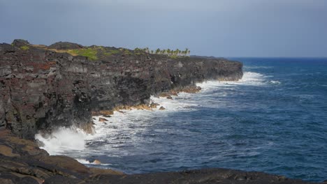Black-lava-flows-that-reached-the-blue-Pacific-ocean-show-cliff-formations-and-some-vegetation-growth