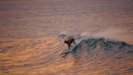 Die-Silhouette-Eines-Einsamen-Surfers,-Der-Auf-Seinem-Brett-Steht,-Während-Die-Sonne-Gerade-An-Der-Nordküste-Von-Oahu-Hawaii-Untergeht