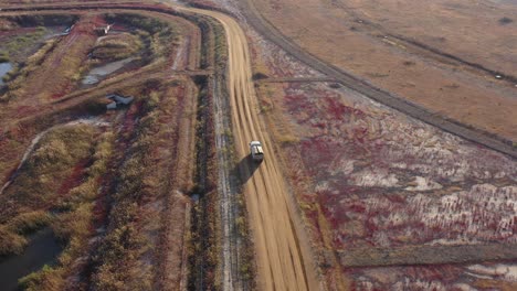 a-white-truck-running-between-native-plants-in-reclaimed-land
