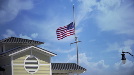 Eine-Amerikanische-Flagge,-Die-An-Einem-Sonnigen-Tag-Auf-Halbmast-Auf-Einem-Hafenhaus-In-Einem-Jachthafen-An-Der-Küste-Von-Mississippi-Weht