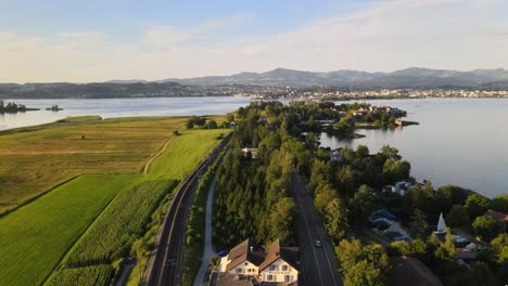 Aerial-drone-shot-rising-above-Hurden-overlooking-Rapperswil-at-sunset-in-summer