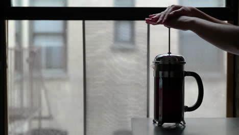 Woman-makes-coffee-in-a-french-press