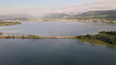 Aerial-drone-shot-flying-sideways-overlooking-the-bridge-between-Rapperswil-and-Hurden-on-a-summer-evening