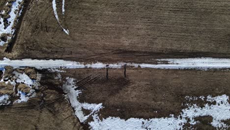Drohnenaufnahme-Aus-Der-Vogelperspektive-Von-Einem-Pärchen,-Das-Mit-Schneeschuhen-Durch-Das-Hinterland-Kanadas-Wandert
