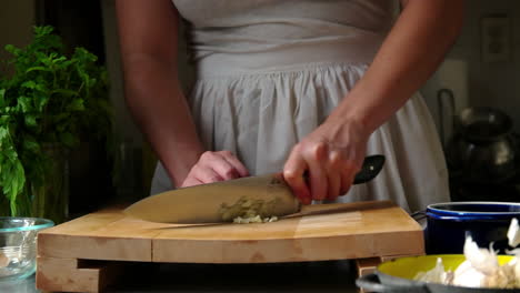 Woman-chops-garlic-on-a-cutting-board