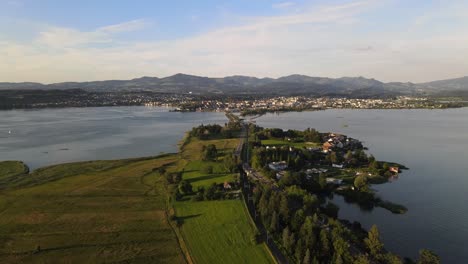 Aerial-drone-shot-flying-sideways-above-Hurden-overlooking-and-flying-towards-Rapperswil-at-sunset-in-summer