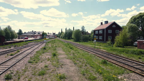 Railroad-in-industrial-area-with-cars-driving-past-in-background