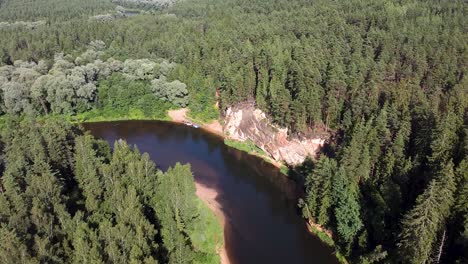 Aerial-drone-view-red-sandstone-cliffs-next-to-Gauja-river-in-Latvia-during-summer