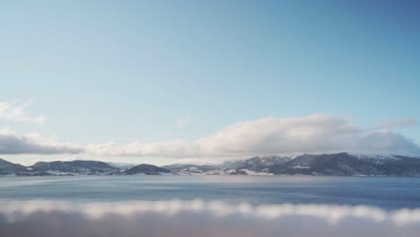 Flauschige-Weiße-Wolken,-Die-Sich-Bei-Tageslicht-Mit-Einem-Kreuzfahrtschiff-über-Den-Fjord-Bewegen