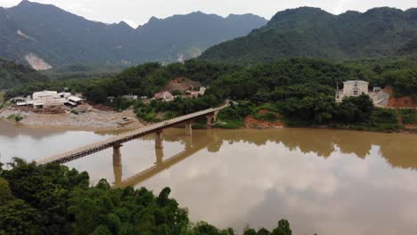 Aerial-shot-slowly-descending-over-bridge-at-Quan-Hóa-District,-Vietnam