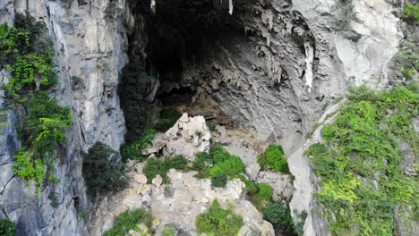 Aerial-Shot-descending-into-the-mouth-of-a-cave-at-Dong-Van,-Vietnam