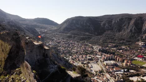 AERIAL---Valley-and-the-ancient-city-of-Kotor-and-its-city-walls,-Montenegro,-reverse