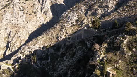 AERIAL---Ancient-city-walls,-Kotor,-Montenegro,-UNESCO-World-Heritage-Site,-reverse