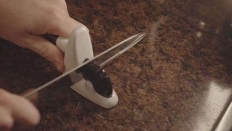 Person-Sharpening-Knife-In-The-Kitchen