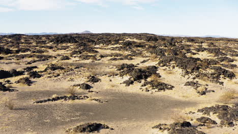 Drone-Vuela-Sobre-El-Desierto-De-Mojave-Del-Sur-De-California-Revelando-La-Formación-Geológica-Del-Campo-De-Lava-Dentro-Del-Monumento-Nacional-De-Los-Senderos-De-Mojave