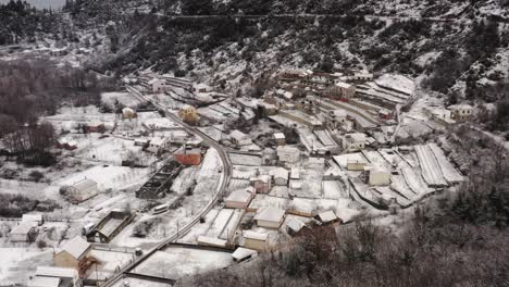 AERIAL---Village-of-Virpazar-in-snowy-winter,-mountains,-Bar,-Montenegro,-truck-right