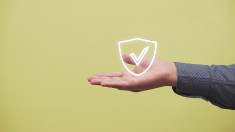 hand-shows-a-shield-with-a-check-mark-icon-on-yellow-background