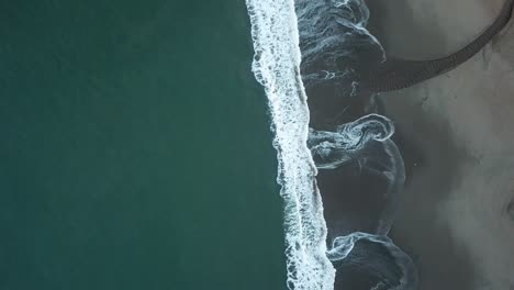 aerial-view-of-tide-crashing-into-beach